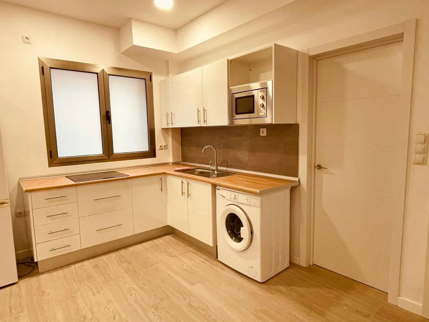 Cocina reformada con encimera de madera y frentes blancos — Proyecto Telde
